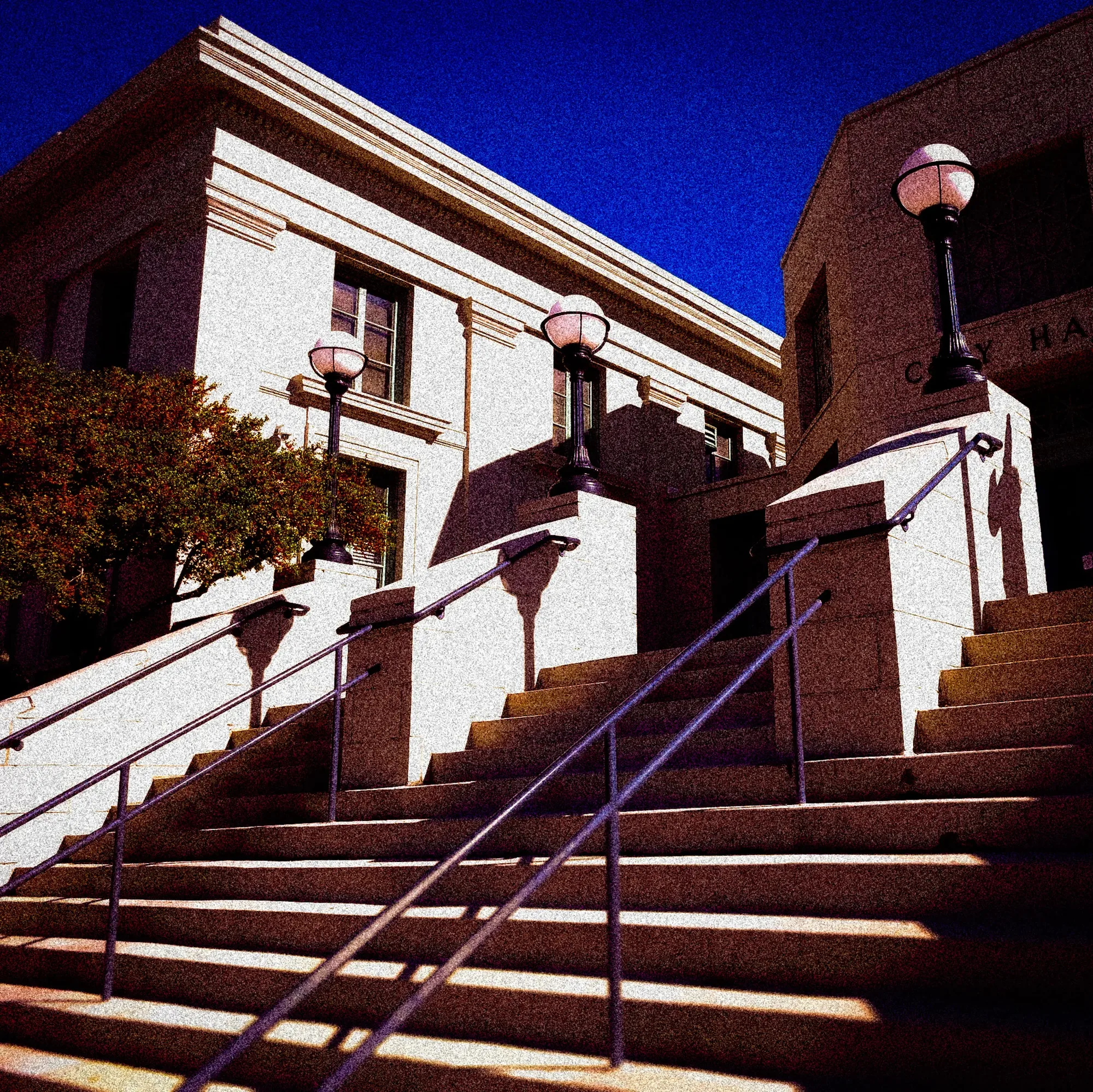 Sunlit stone building and steps beneath a deep blue sky