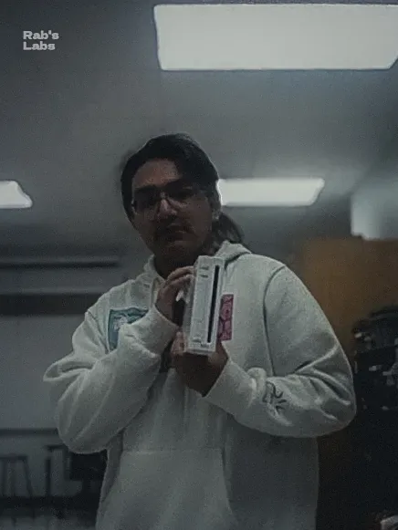 Person in a white coat holding a red-and-white object