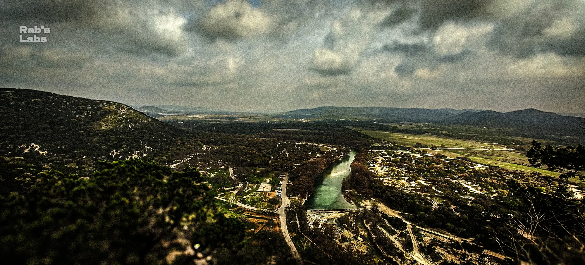 River winding through a broad rocky valley under broken clouds