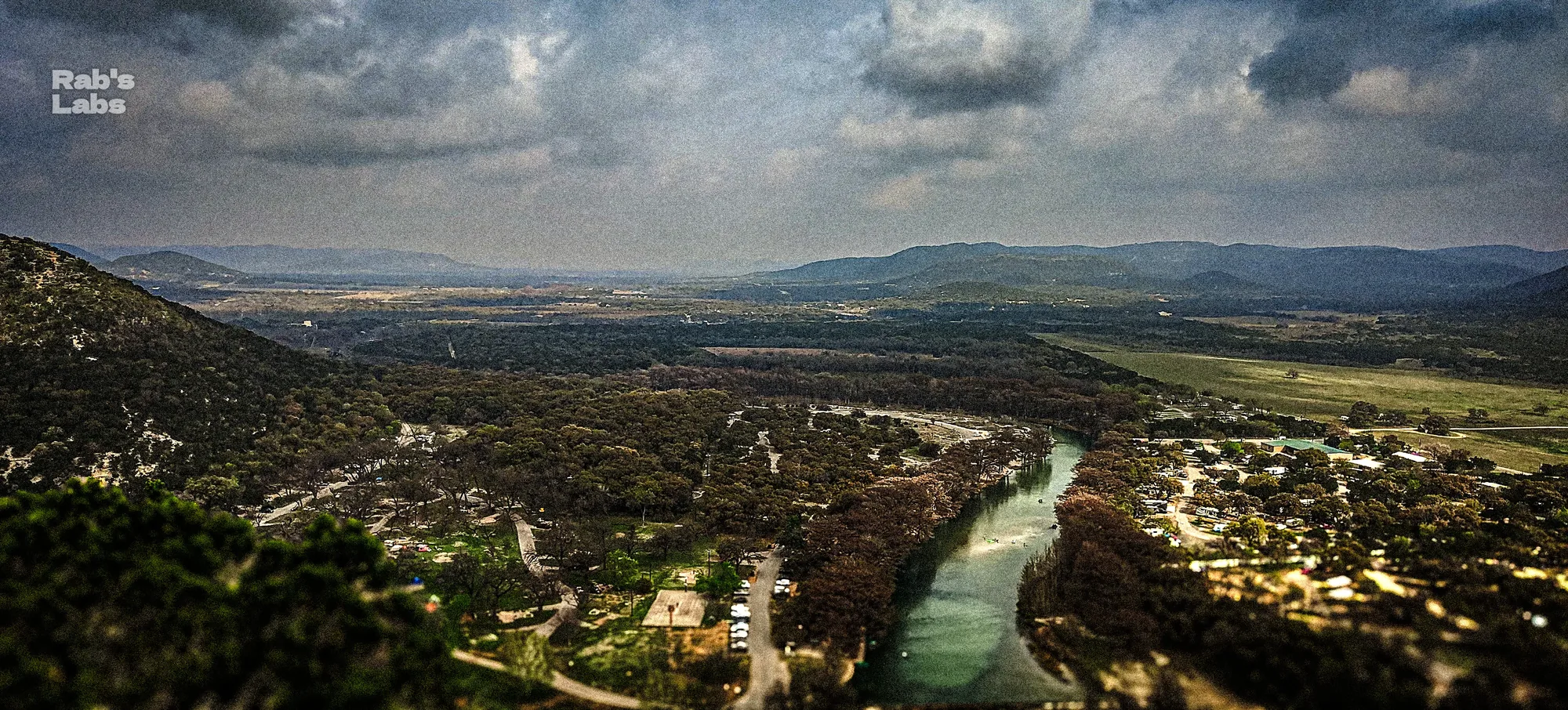 Wide elevated view of a river crossing a rugged valley